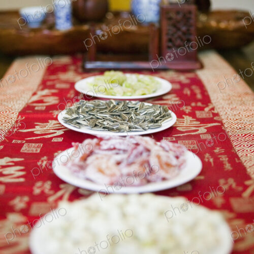 Close up of dishes of snacks with tea set on table.