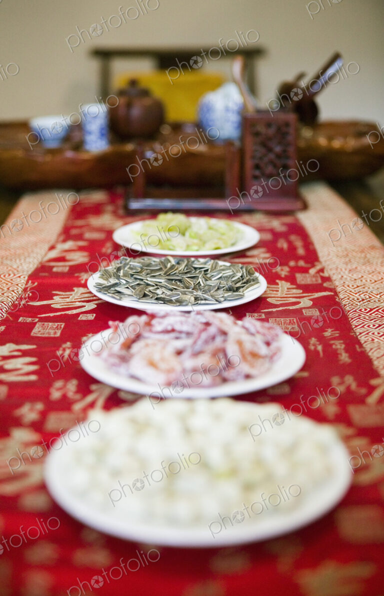 Close up of dishes of snacks with tea set on table.