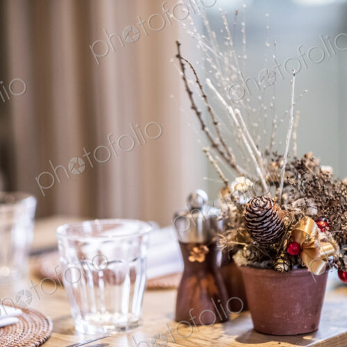 Close up of drinking glasses and Christmas decorations on wooden dining table. Close up of drinking glasses and Christmas decorations on wooden dining table.