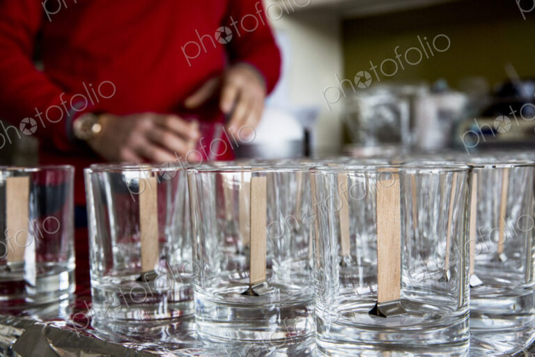 Close up of empty glass jars with wooden wicks, for candle making.