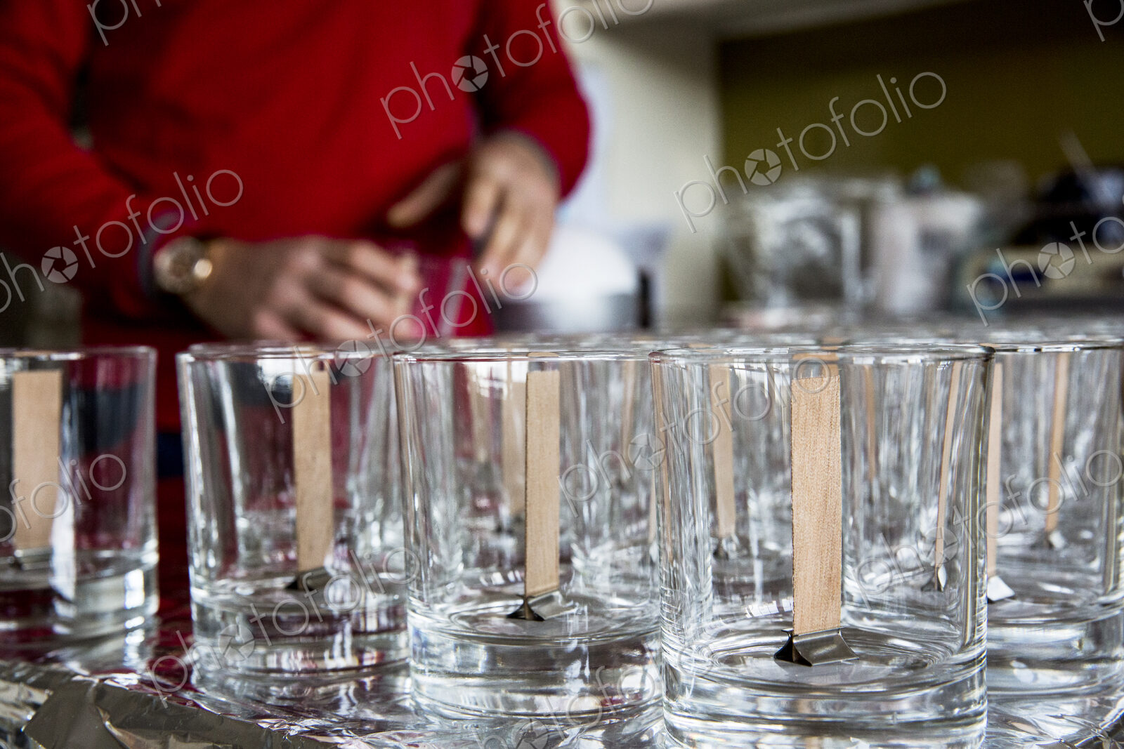 Close up of empty glass jars with wooden wicks, for candle making.