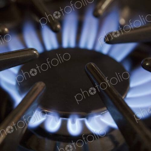 Close up of gas hob with the burner lit. Power heat and energy. Blue flames