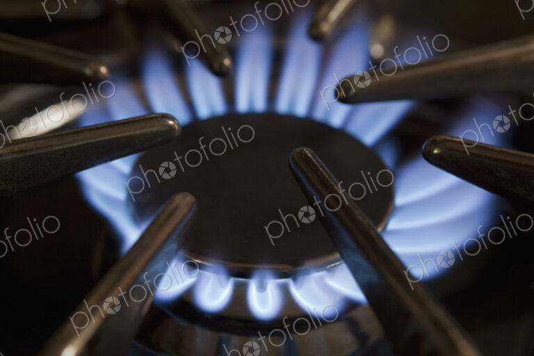 Close up of gas hob with the burner lit. Power heat and energy. Blue flames
