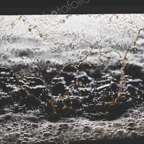 Close up of grape juice pouring into vat at a vineyard.