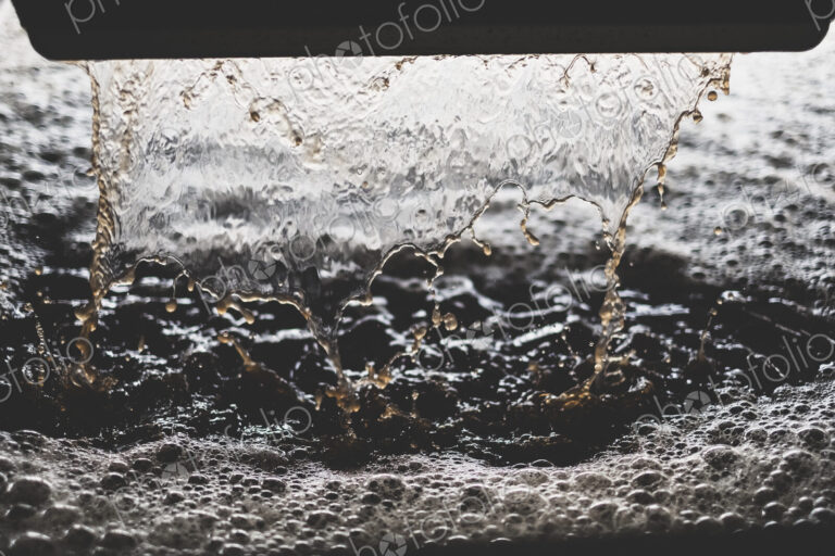 Close up of grape juice pouring into vat at a vineyard.