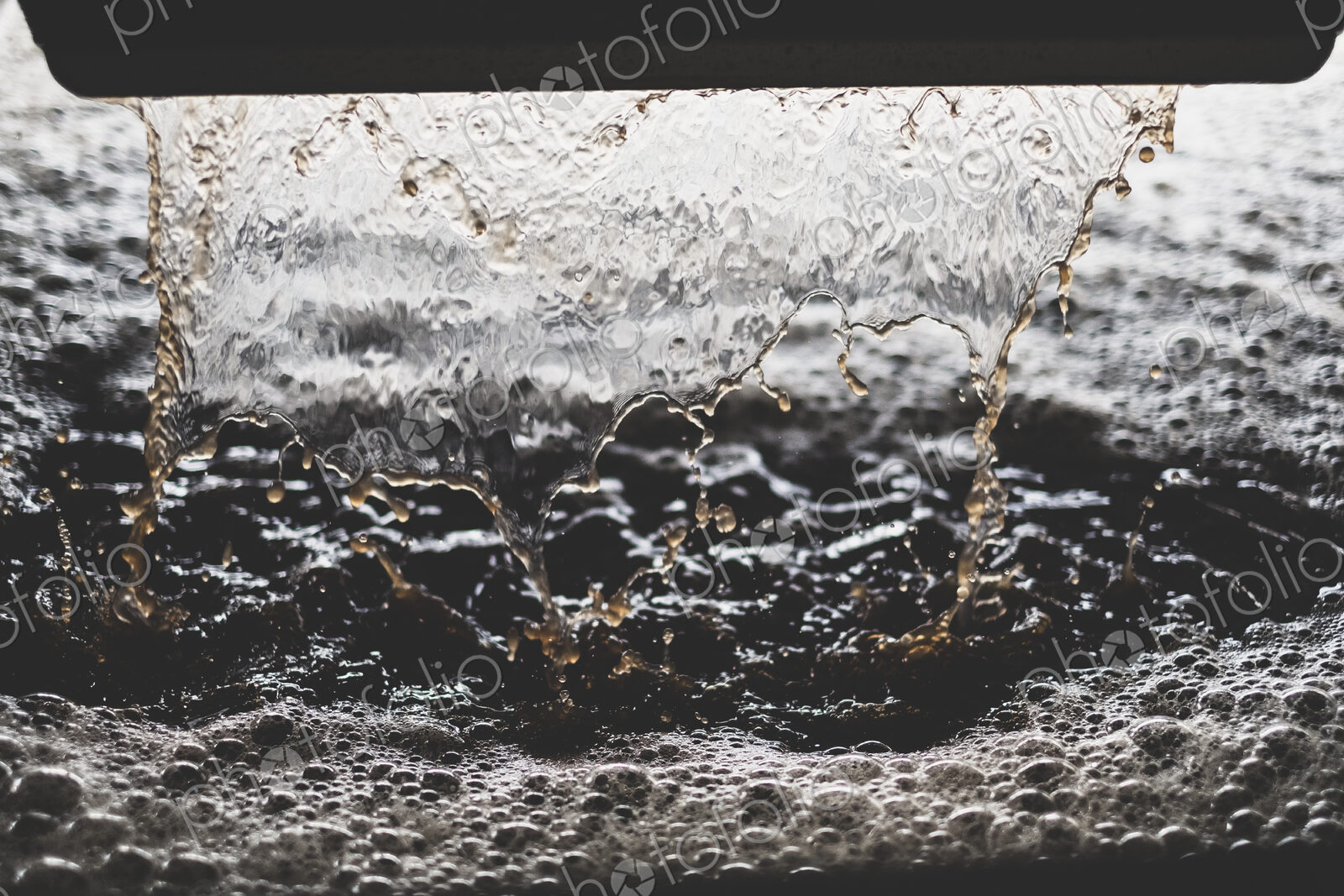 Close up of grape juice pouring into vat at a vineyard.