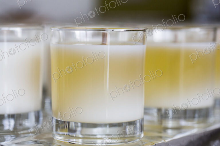 Close up of handmade white and yellow jar candles with wooden wick.