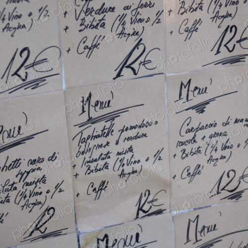 Close up of handwritten set menus on the wall at an Italian restaurant.