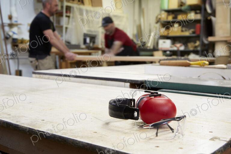 Close up of headphones and safety goggles on workshop table