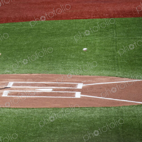 Close up of home plate on baseball field, hand with baseball glove about to catch… Close up of home plate on baseball field, hand with baseball glove about to catch…