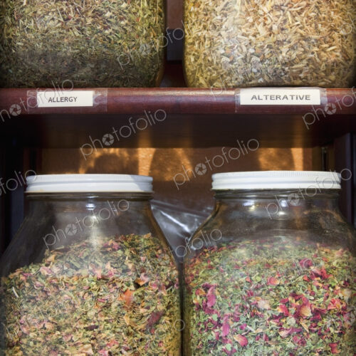 Close up of jars of medicinal dried herbs and plants on shelves in apothecary shop. Close up of jars of medicinal dried herbs and plants on shelves in apothecary shop.