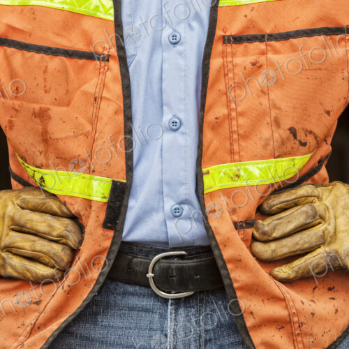 Close-up of landscape company worker wearing work gloves and safety vest Close-up of landscape company worker wearing work gloves and safety vest