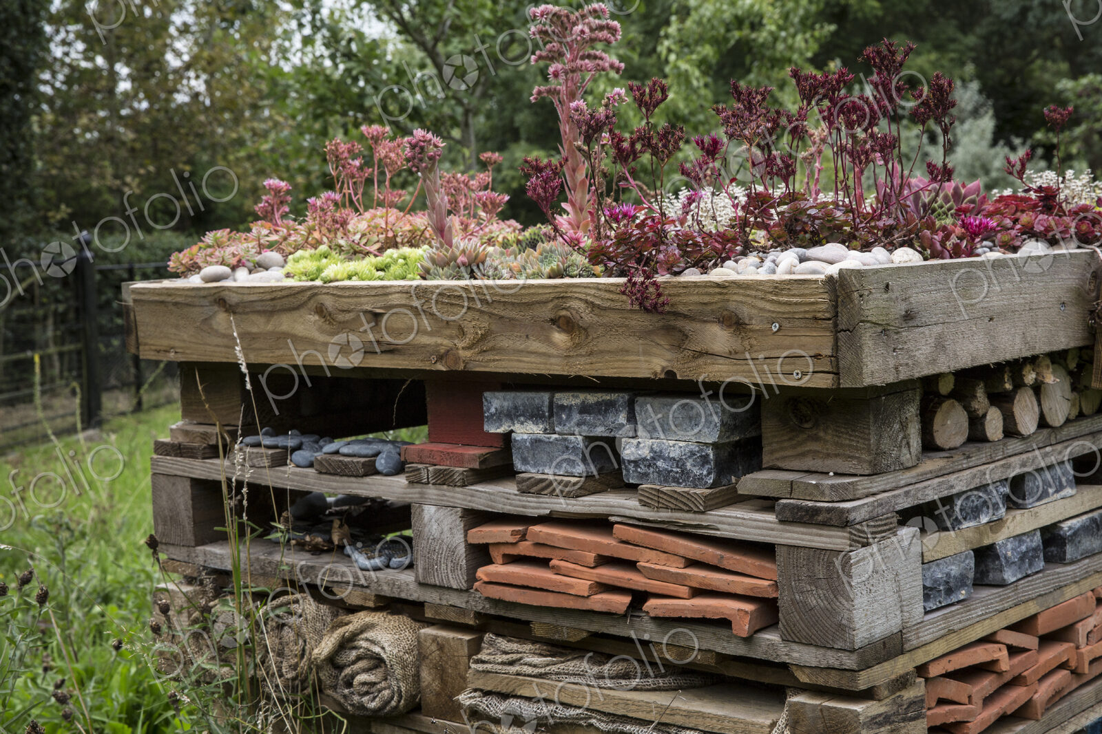 Close up of large bug house with several layers of different materials.