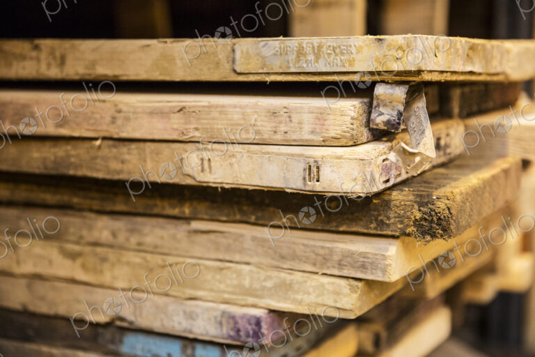 Close up of large selection of wooden planks stacked on shelves in a warehouse.