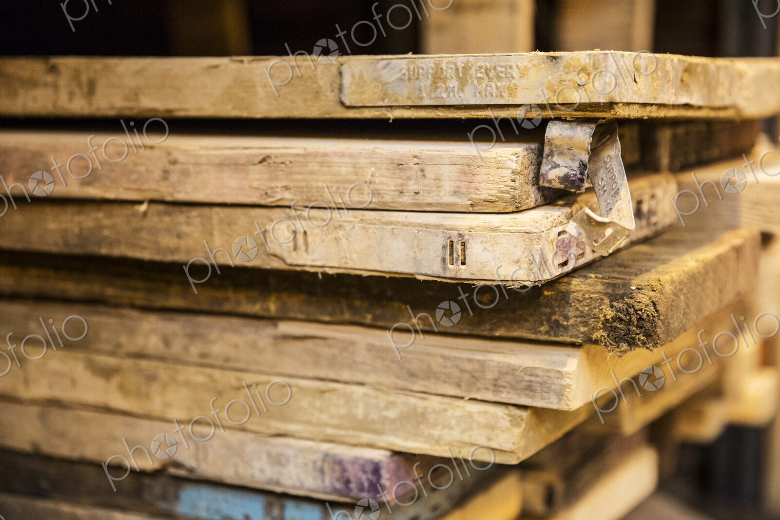 Close up of large selection of wooden planks stacked on shelves in a warehouse.