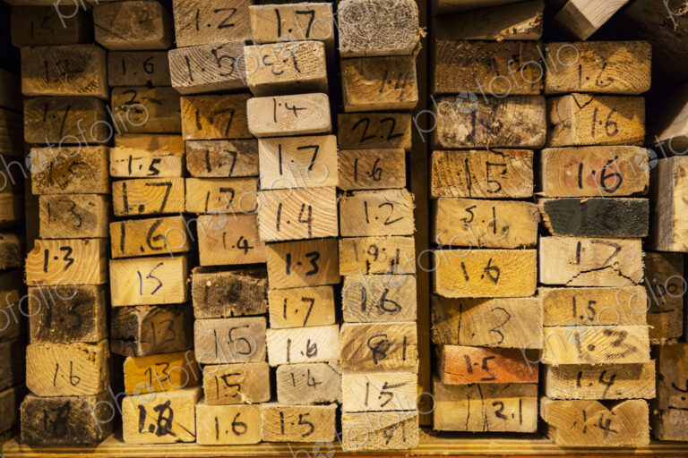 Close up of large selection of wooden planks stacked on shelves in a warehouse.