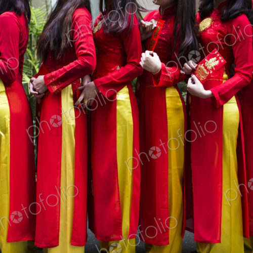 Close up of line of young women in traditional red and yellow dress outside of a wedding. Close up of line of young women in traditional red and yellow dress outside of a wedding.