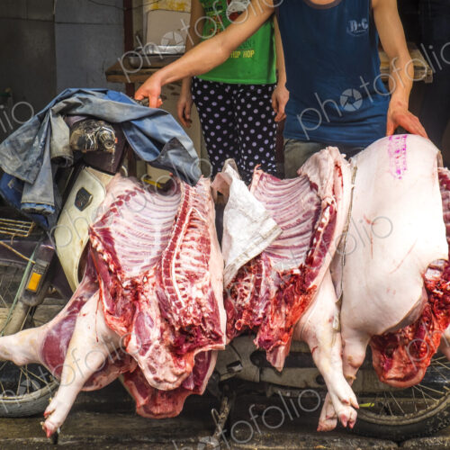 Close up of man transporting three pig carcasses on an old motor-scooter. Close up of man transporting three pig carcasses on an old motor-scooter.