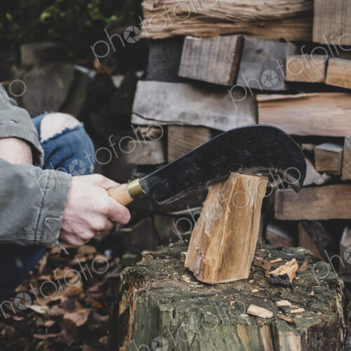 Close up of man using machete cleaver on chopping block, splitting piece of wood. Close up of man using machete cleaver on chopping block, splitting piece of wood.