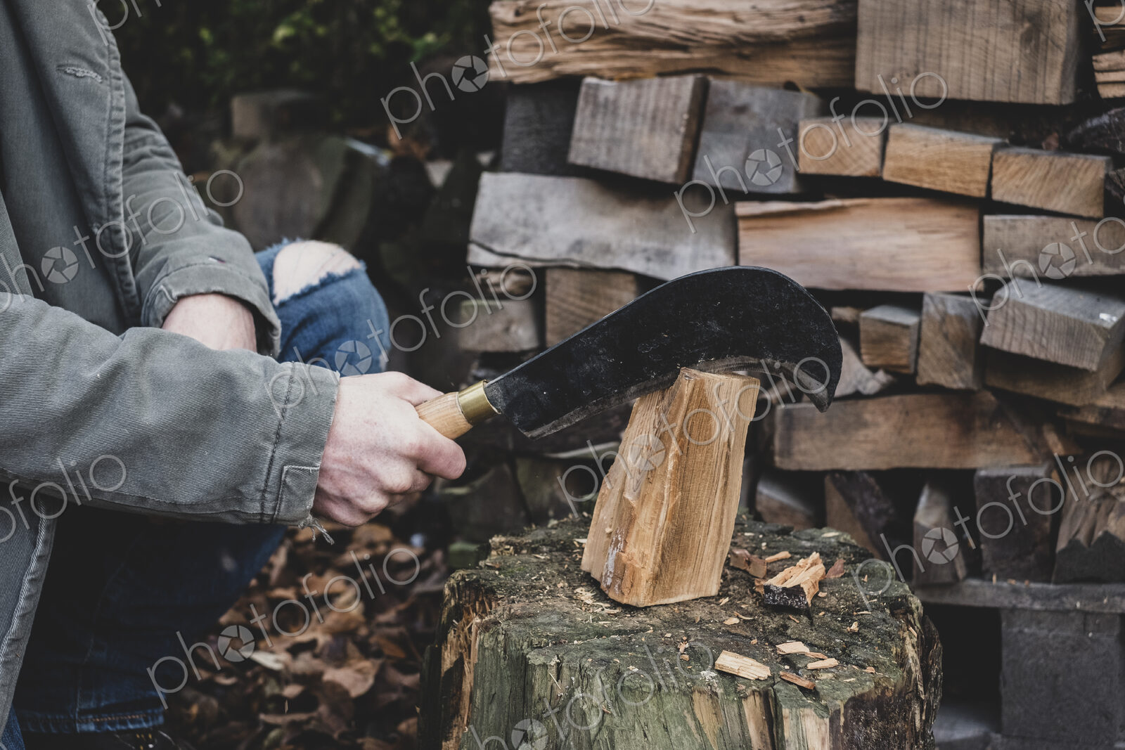 Close up of man using machete cleaver on chopping block, splitting piece of wood.