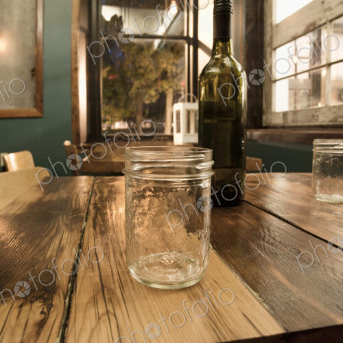 Close up of mason jars and wine bottle on table