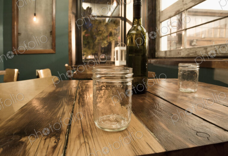 Close up of mason jars and wine bottle on table