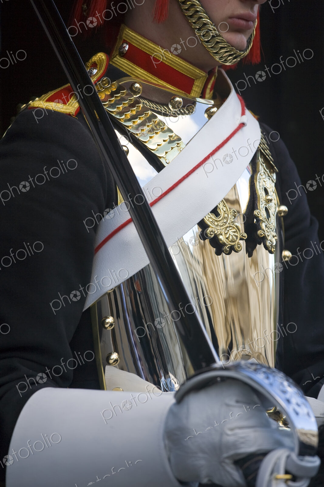 Close up of member of the Blues and Royals, with polished cuirass and sash, holding sword.