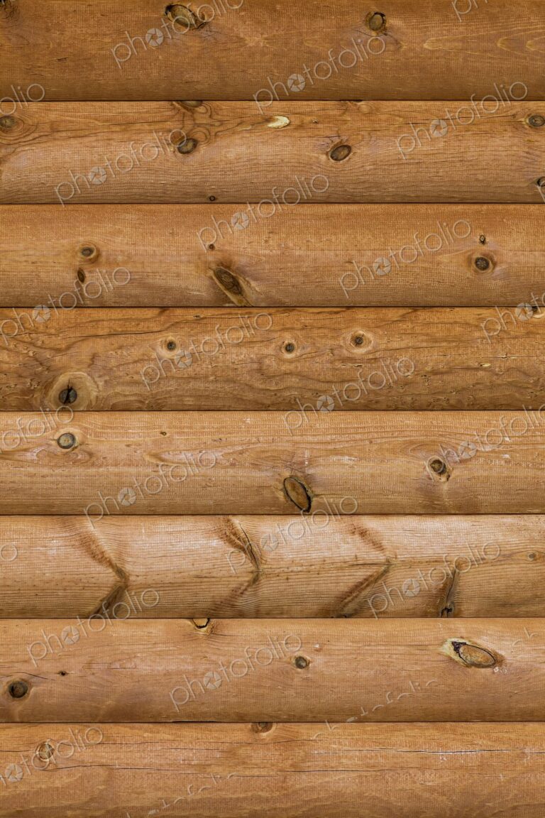 Close-up of natural wood texture and knots in a log cabin wall, highlighting rustic…