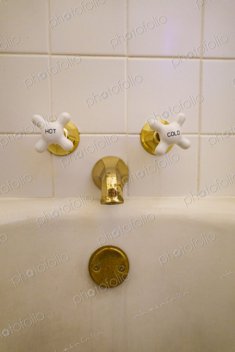 Close-up of old-fashioned bathtub faucet and drain.