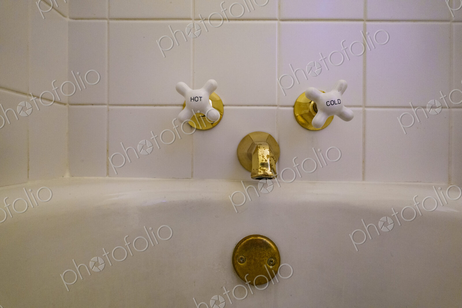 Close-up of old-fashioned bathtub faucet and drain.