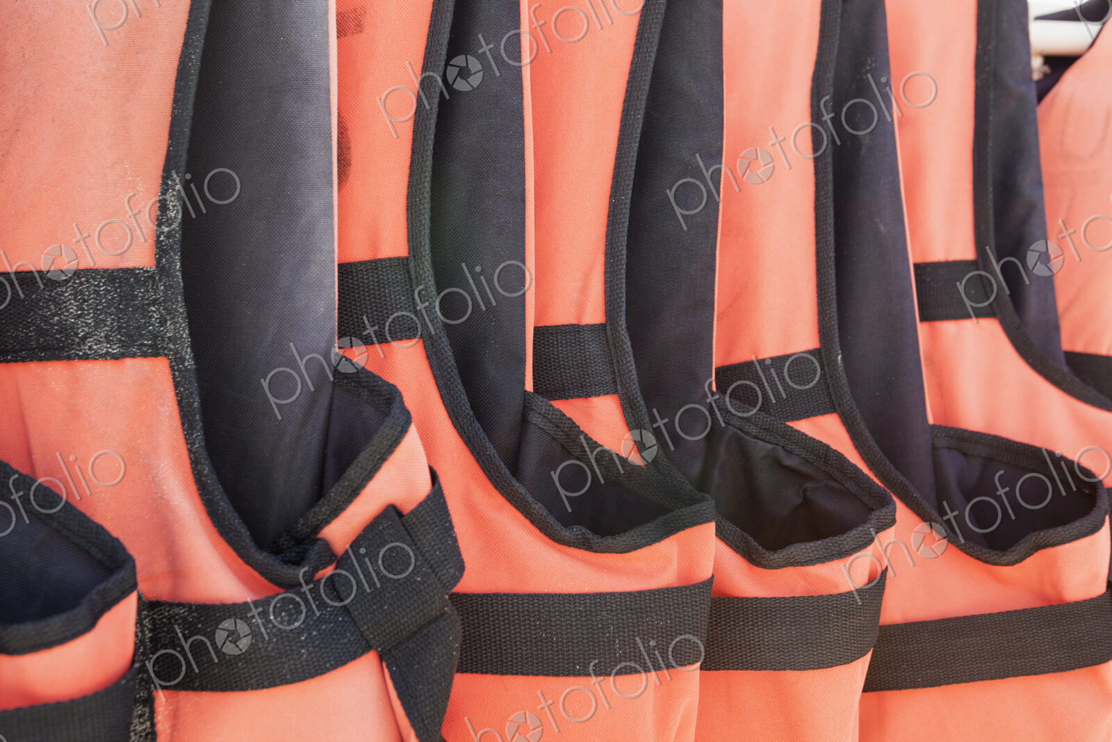 Close-up of orange life jackets in a row