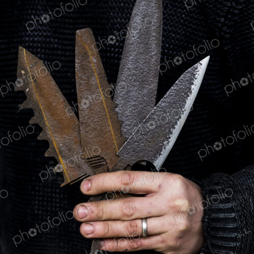 Close up of person holding a selection of partially rusted and serrated knife blades. Close up of person holding a selection of partially rusted and serrated knife blades.