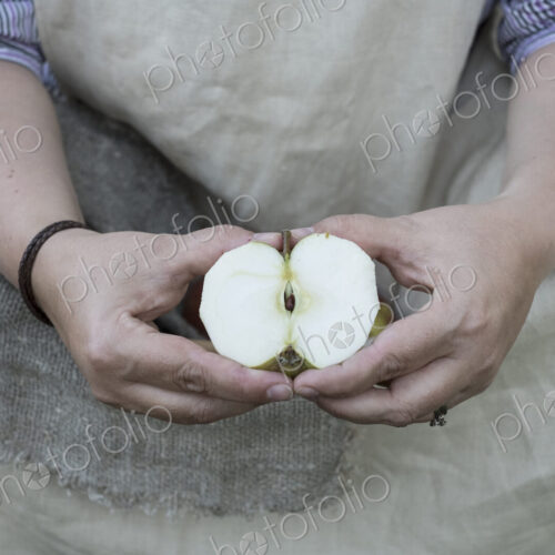 Close up of person holding apple cut in half. Close up of person holding apple cut in half.