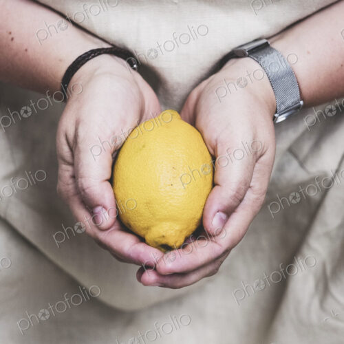Close up of person holding fresh lemon. Close up of person holding fresh lemon.