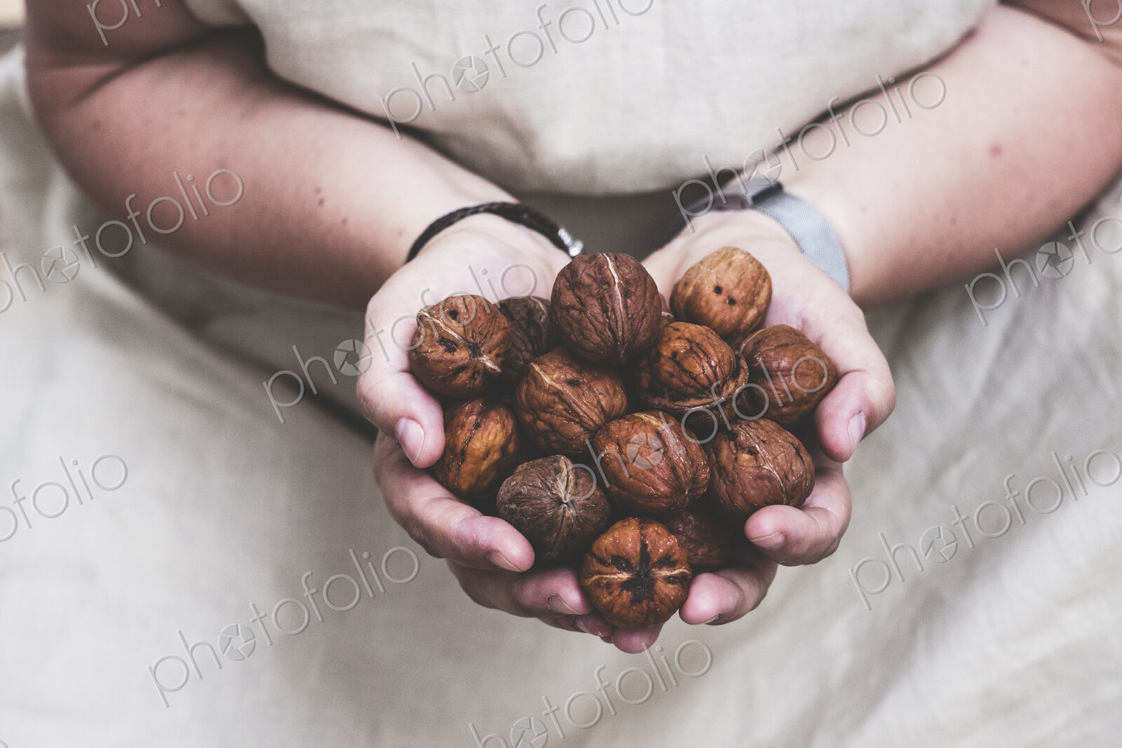 Close up of person holding fresh walnuts.