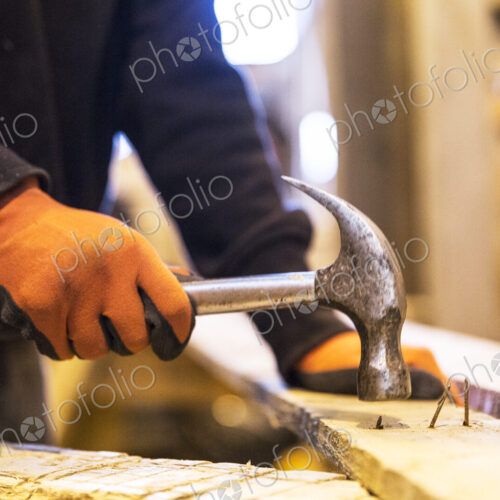 Close up of person wearing work gloves holding, hammer, removing rusty nails from… Close up of person wearing work gloves holding, hammer, removing rusty nails from…