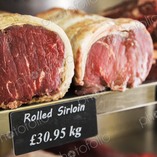 Close up of piece of rolled beef sirloin meat on a metal shelf in the chiller at a…