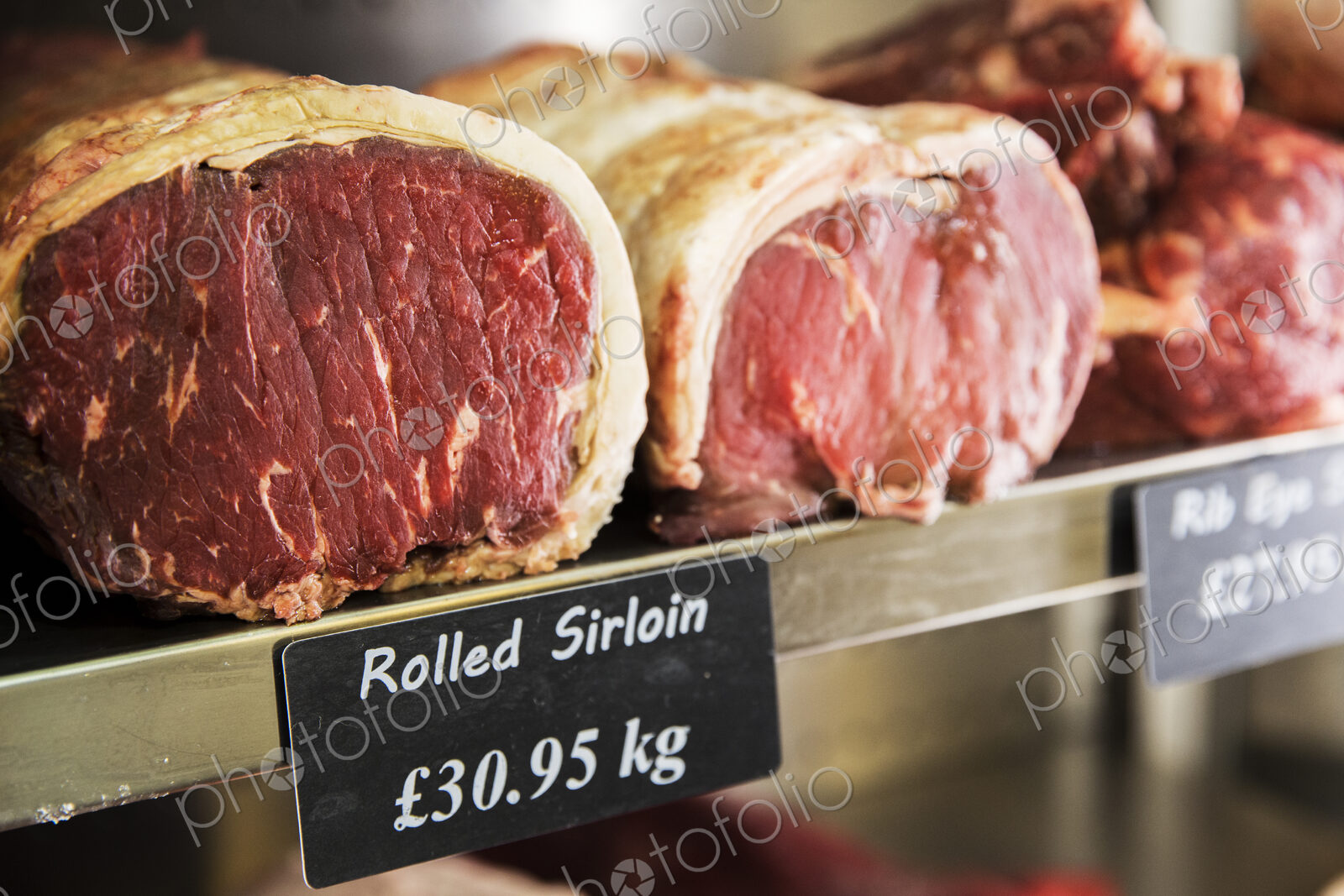 Close up of piece of rolled beef sirloin meat on a metal shelf in the chiller at a…