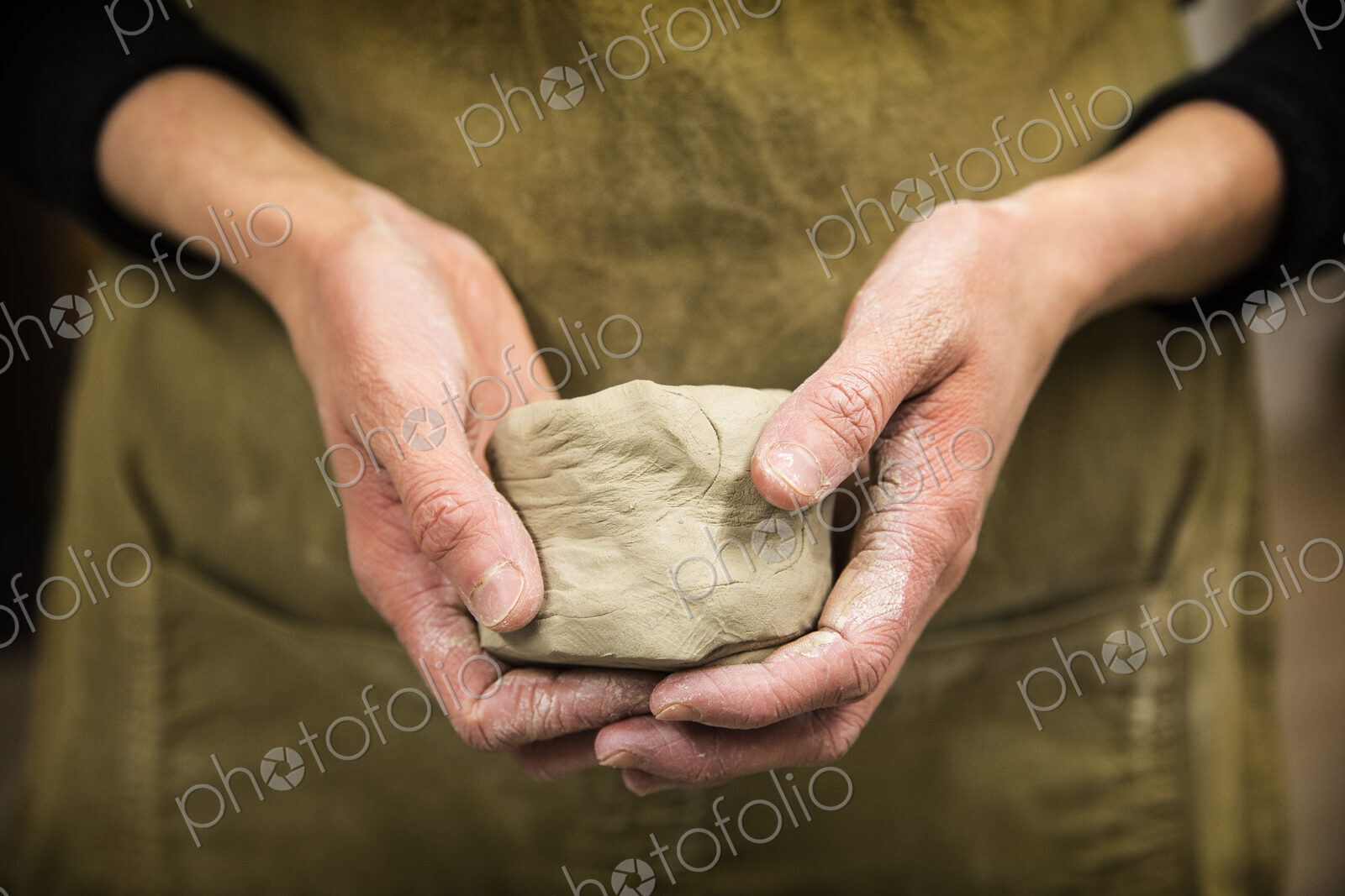 Close up of potter holding piece of pottery clay.