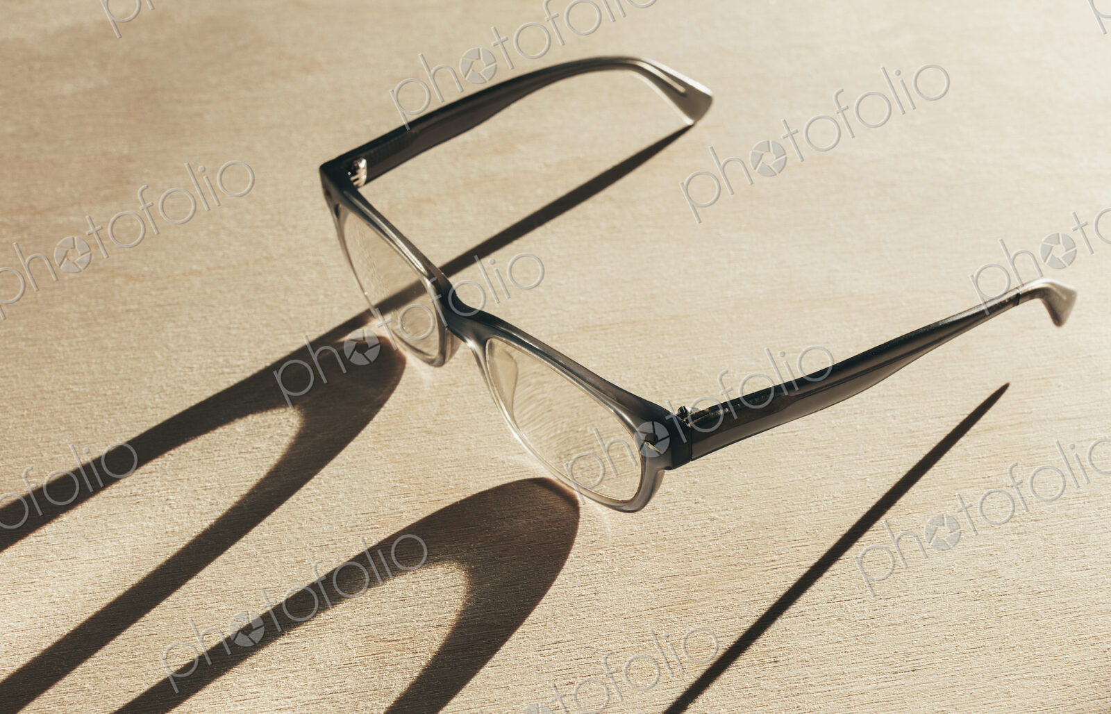 Close up of reading glasses casting long shadow