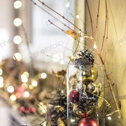 Close up of red and golden Christmas decorations in a vase, bauble, leaves and twigs. Close up of red and golden Christmas decorations in a vase, bauble, leaves and twigs.
