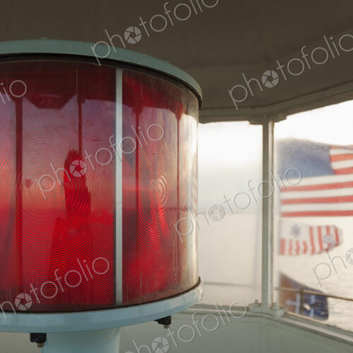 Close up of red lamp and American flags in a lighthouse, Chesapeake Bay, Virginia, USA. Close up of red lamp and American flags in a lighthouse, Chesapeake Bay, Virginia, USA.