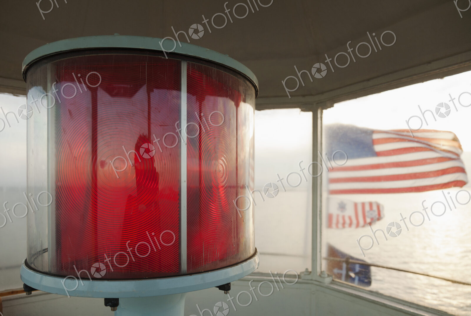 Close up of red lamp and American flags in a lighthouse, Chesapeake Bay, Virginia, USA.