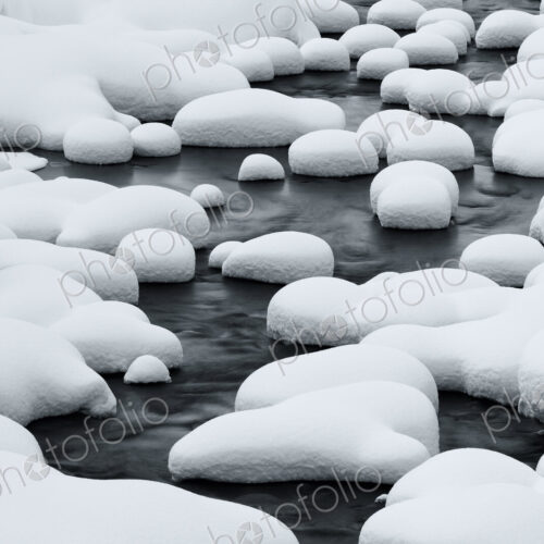 Close up of riverbed with snow-covered rocks in winter. Close up of riverbed with snow-covered rocks in winter.