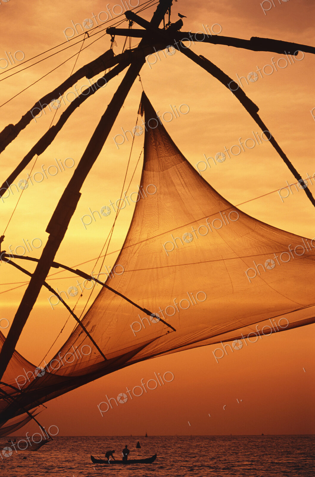 Close up of sail of traditional boat at dusk, two fisherman in a fishing boat.