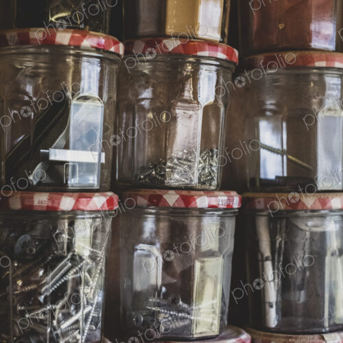Close up of stack of jam jars containing selection of nail and screws. Close up of stack of jam jars containing selection of nail and screws.