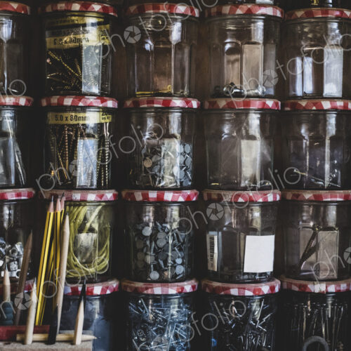 Close up of stack of jam jars containing selection of nail and screws. Close up of stack of jam jars containing selection of nail and screws.