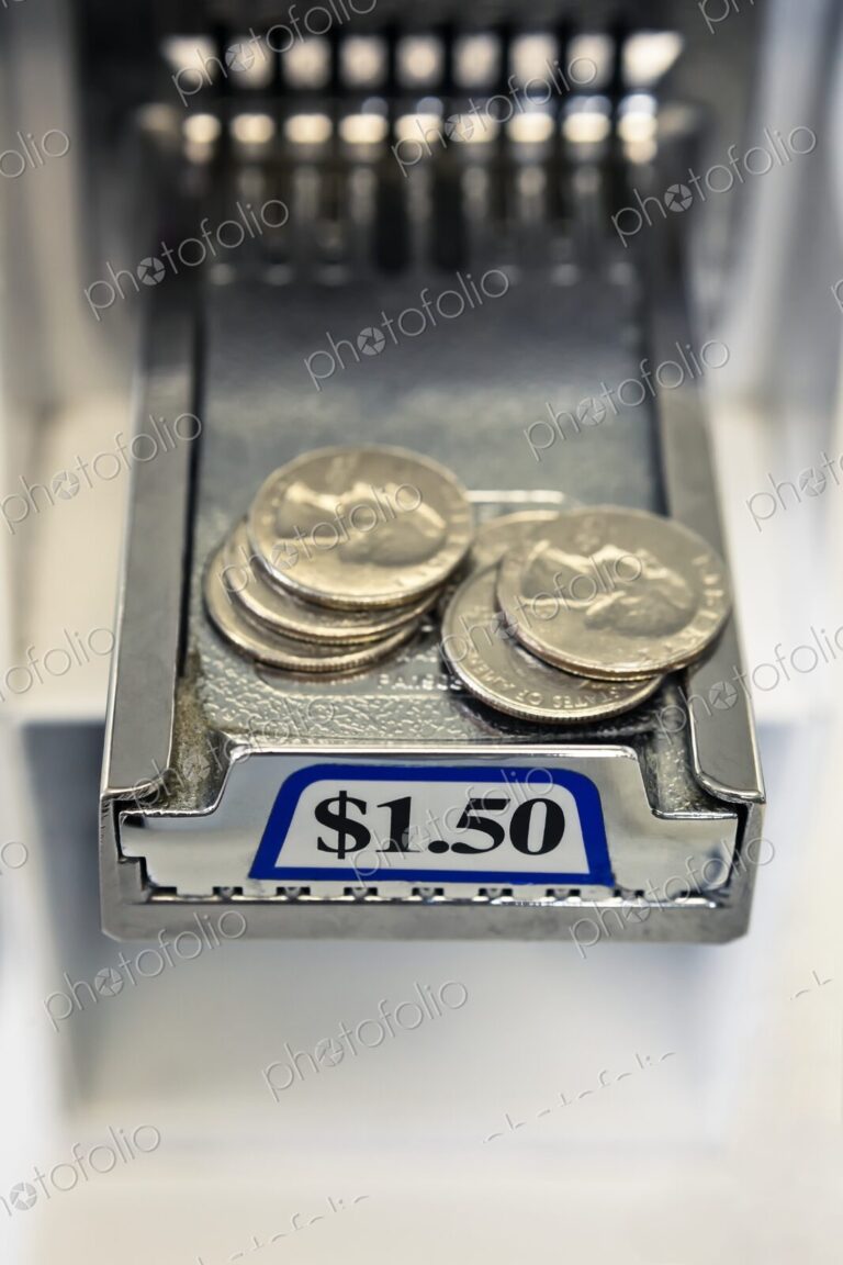 Close-up of stacks of United States coins, quarters on the sliding payment tray of a…