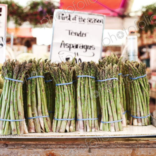 Close up of stacks of fresh green asparagus at a fruit and vegetable market. Close up of stacks of fresh green asparagus at a fruit and vegetable market.