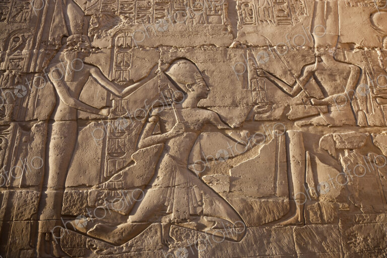 Close up of stone wall with ancient Egyptian bas-relief depicting Pharaoh.